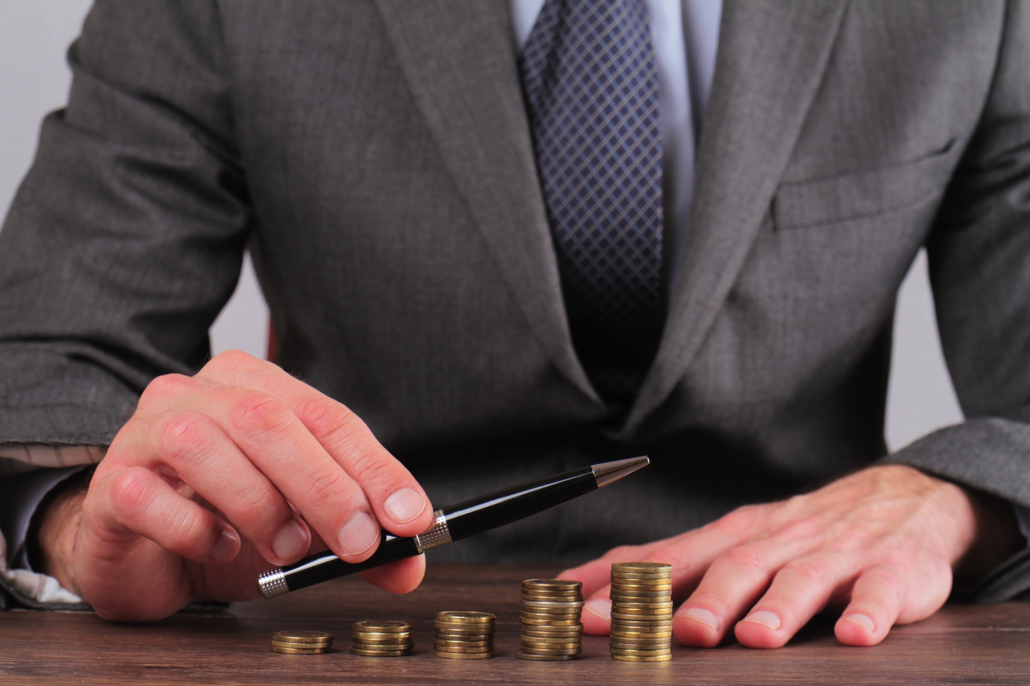 man and pen over money pen and money